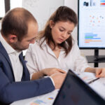 Colleagues of startup business discussing looking at documents