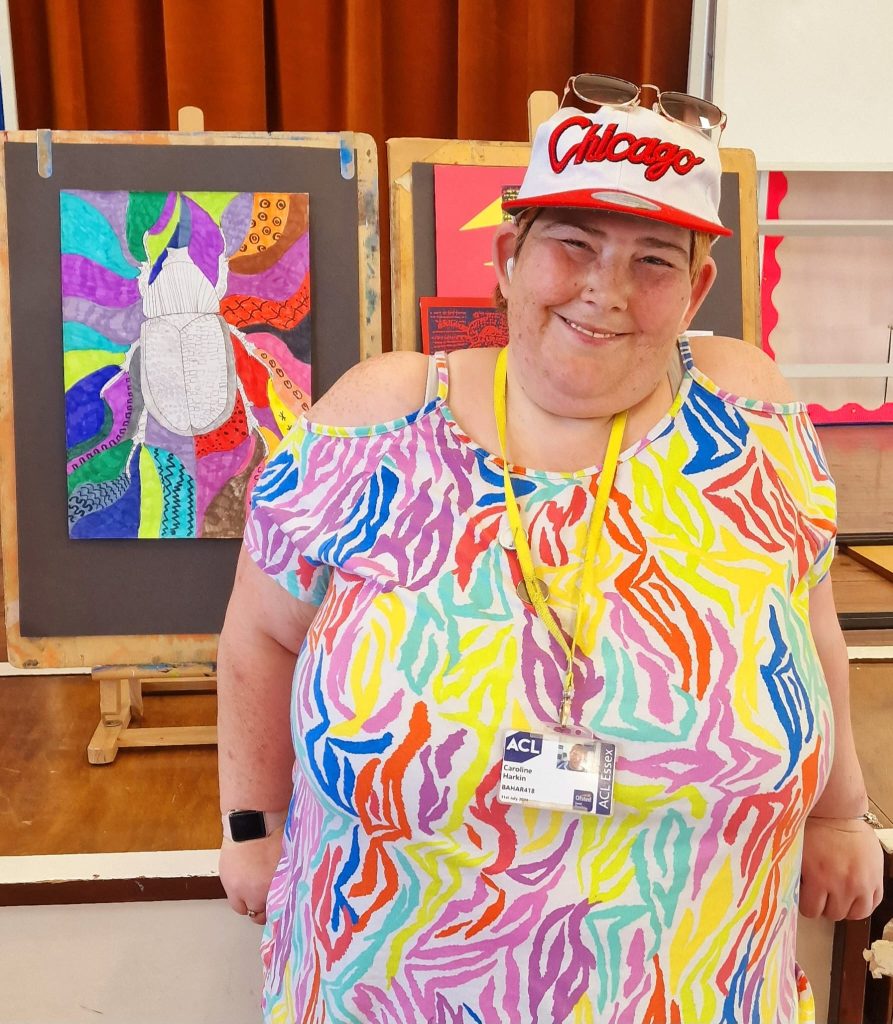 lady in colourful t shirt standing next to art work