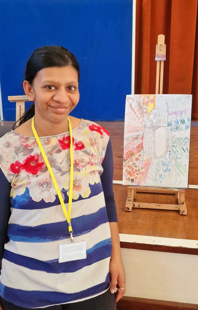 Lady standing next to art work