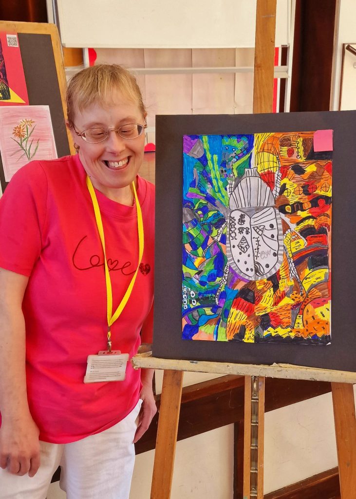 Lady standing next to art work